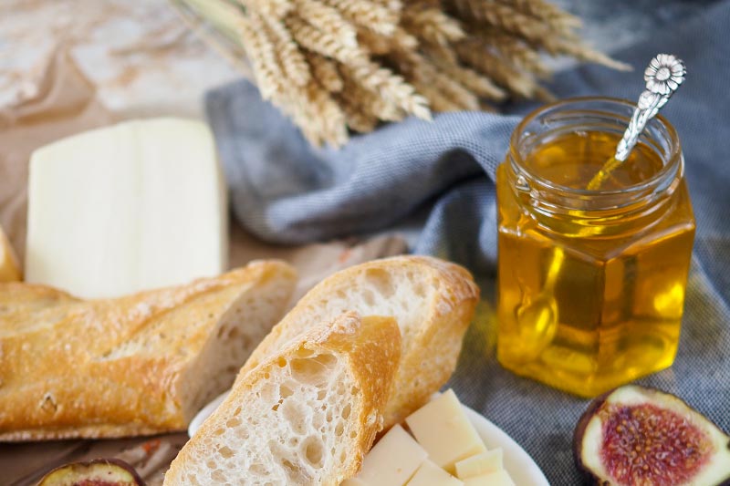 Ouvrir Le Pot De Verre De Miel Liquide Avec Nid D'abeilles À L'intérieur,  Coulant Le Miel De La Louche De Miel, Les Myrtilles Fraîches Et La Grappe  De Lavande Sèche Sur La